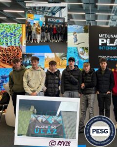 Group of teens posing for a photo at a travel fair in front of a colorful collage wall and a Place2Go banner sign.