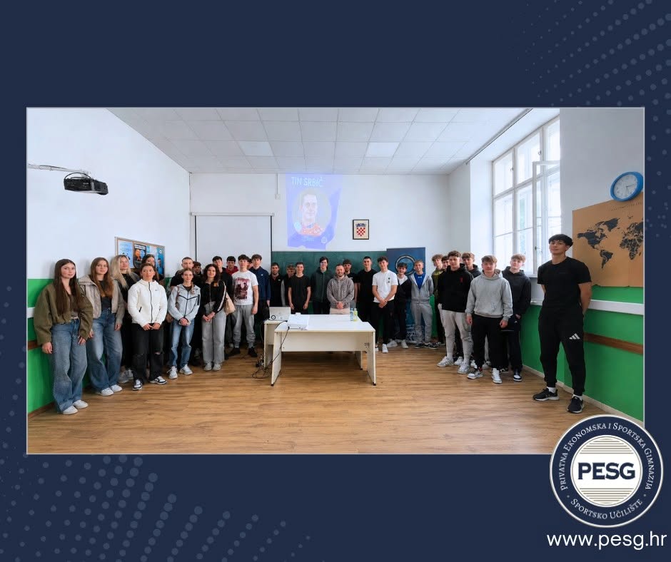 Group of students in a classroom posing for a photo around a central desk, with a projector screen and a world map on the walls; PESG logo visible in the corner.